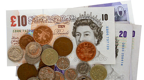 A pile of coins on notes. 