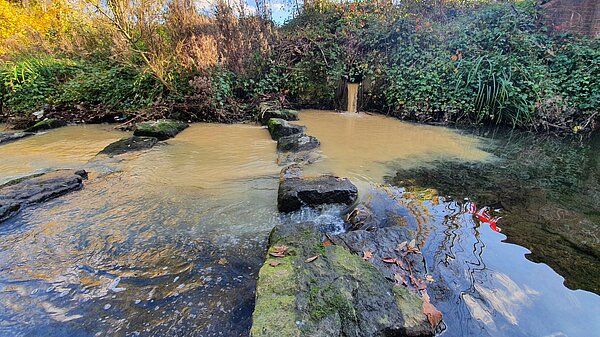 Sewage leaking into a river.